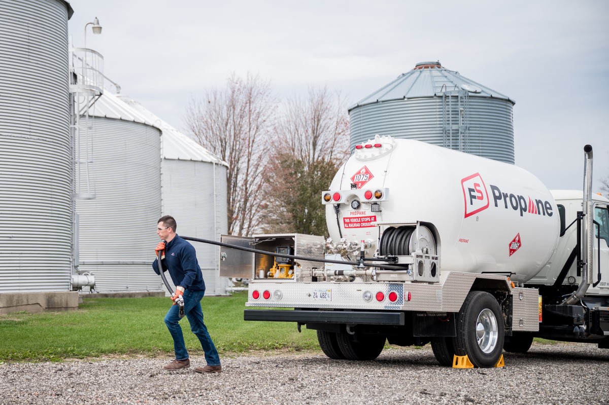 specialist pulling hose from propane delivery truck